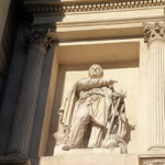 Beeld van Pytheas in marmer, met klassieke architectuur en zuilen, in beige steen die verwijst naar ontdekkingsreizen richting IJsland.